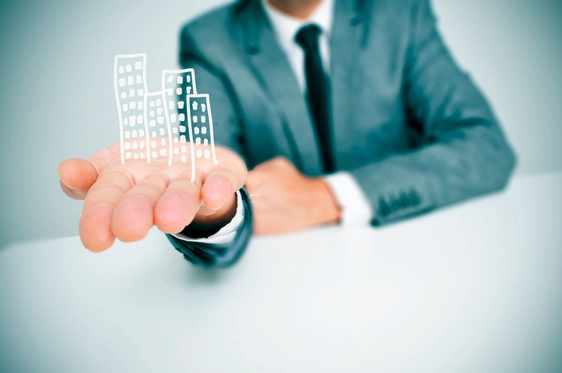 A man in a suit holding a paper city.